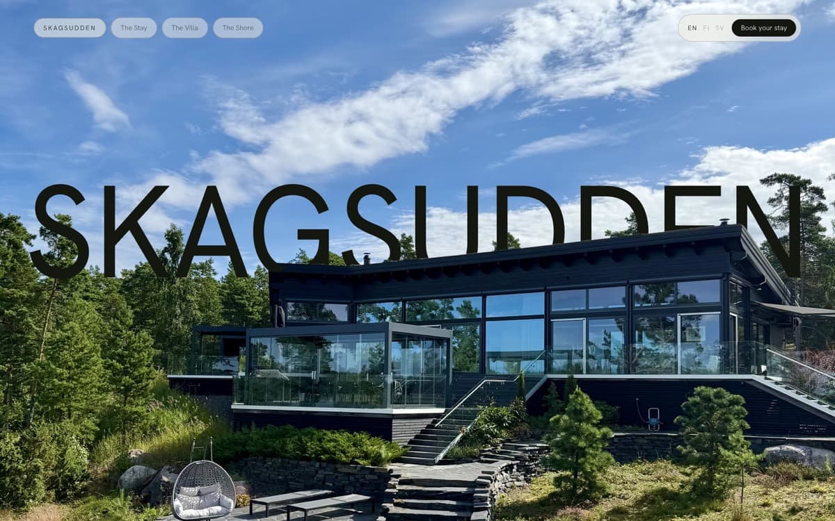 Skagsudden homepage — black timber villa under a summer sky, name set across it.