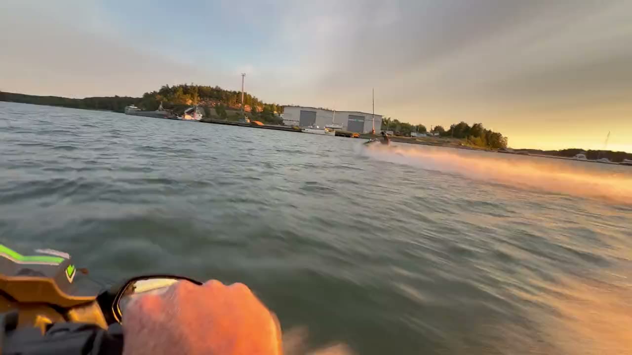 Riding a jet ski towards another rider at sunset