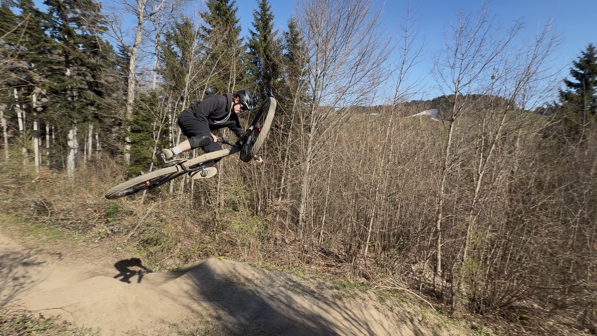 A mountain-bike jump over a forest trail