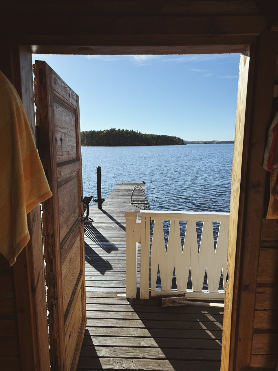 An open cabin door looking out toward a lake